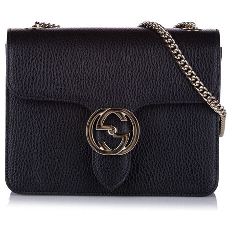 cream gucci purse next to a black purse